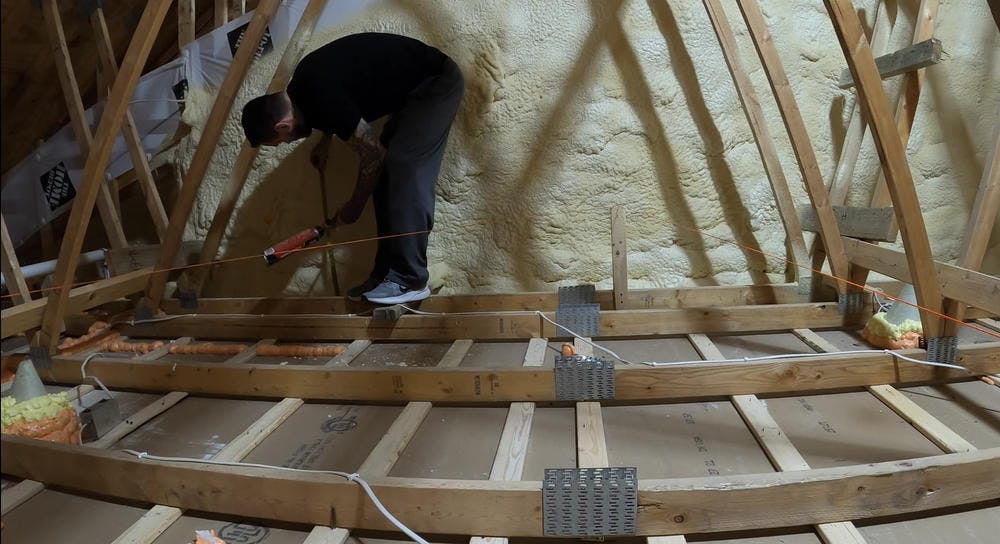 Man spraying foam insulation in the attic in Seattle, WA.