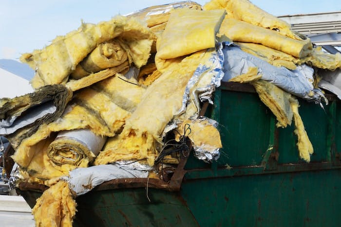 Fiberglass insulation material in a dumpster.